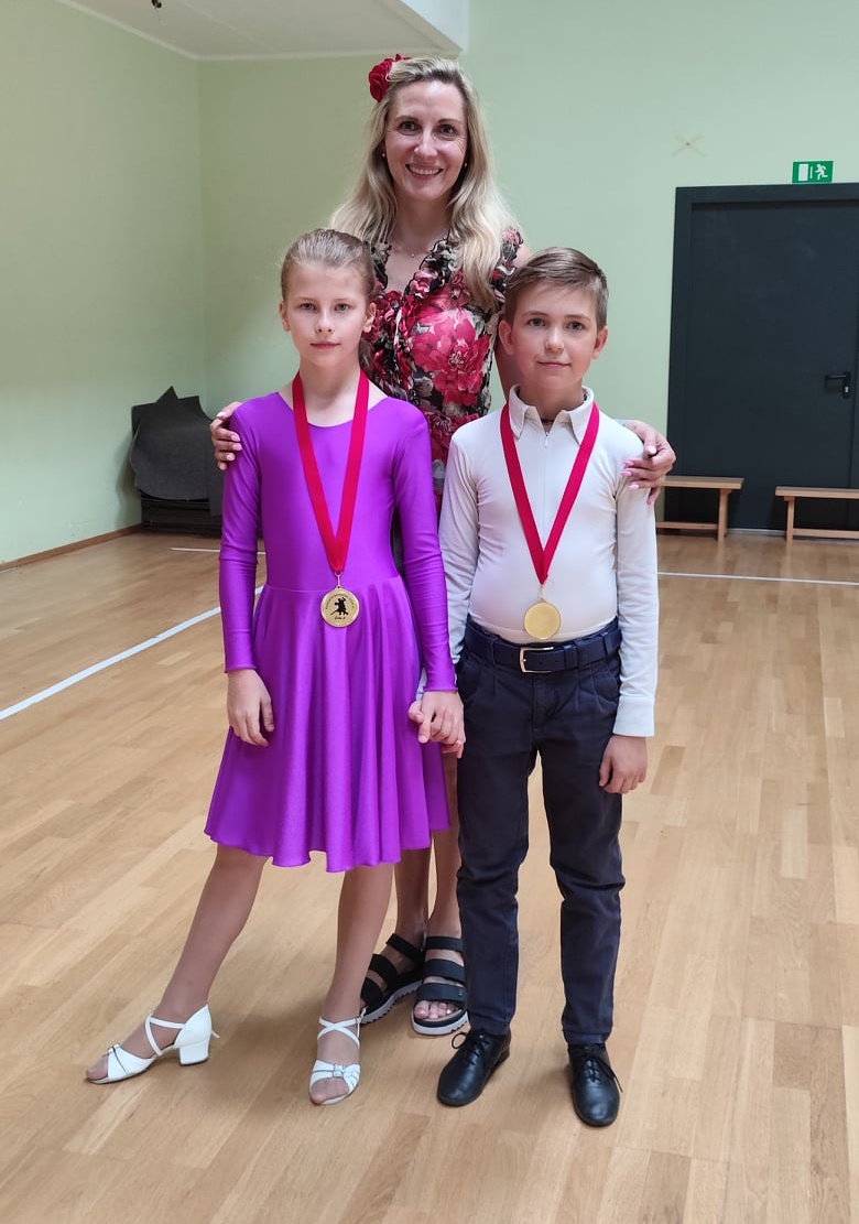 Šokių vadovė su mokiniais, apdovanotais medaliais